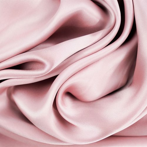 A close up of a pink satin fabric, perfect for skin care or Pillowtex 100% Mulberry Silk Pillowcase with Zipper Enclosure, 16 Momme.